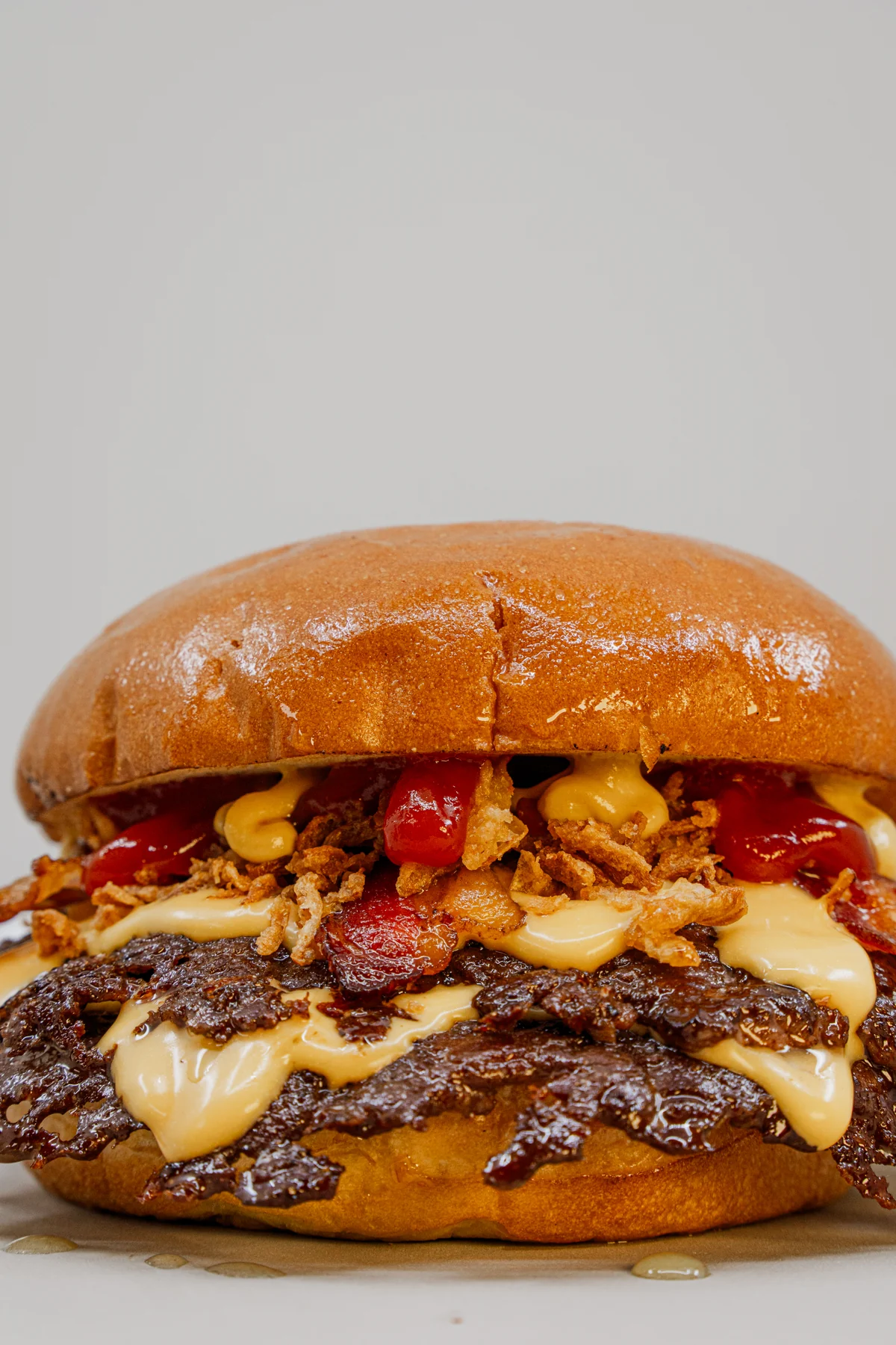 Detalle real de Éxtasis: carne smash, cheddar y bacon
